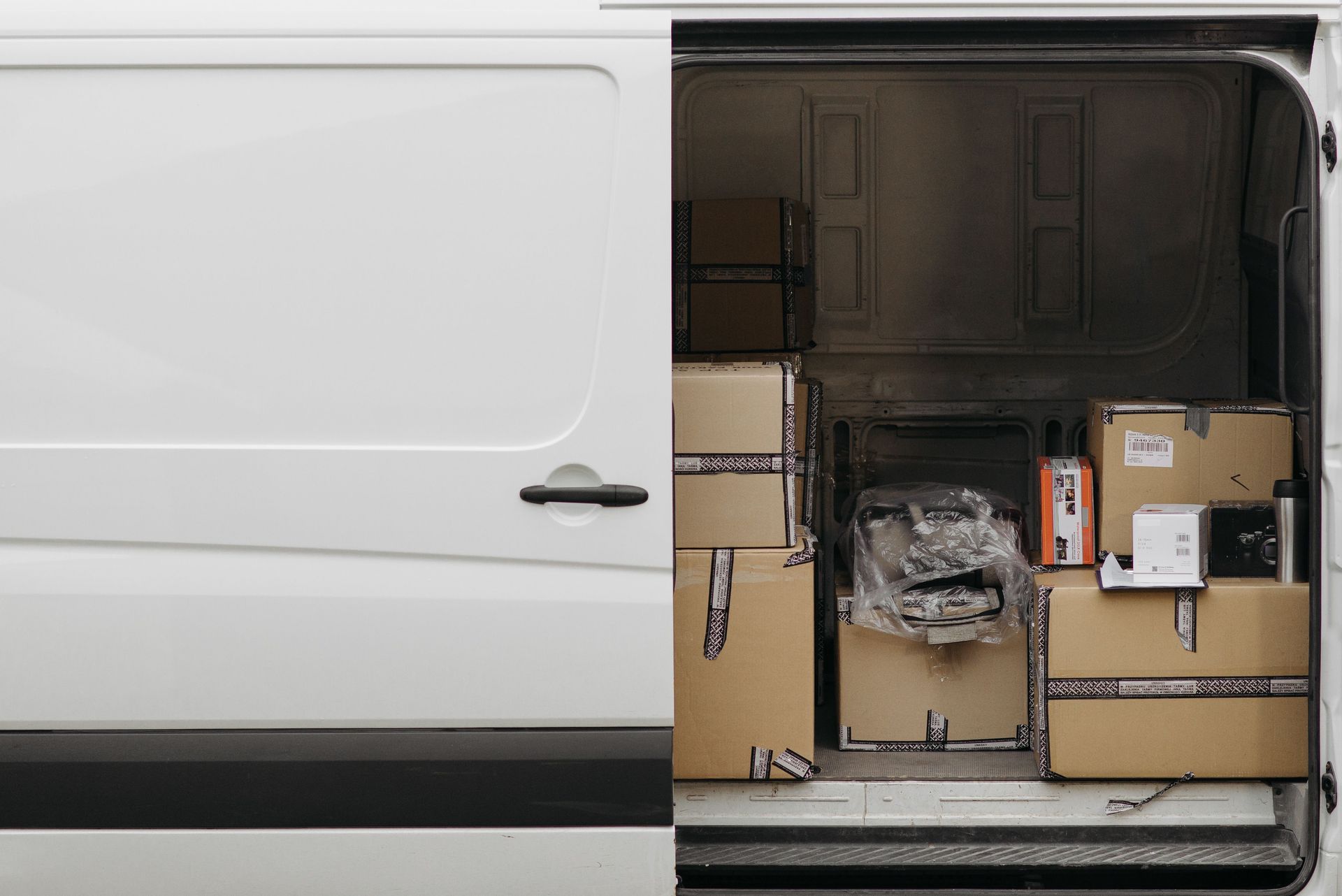 Open delivery van filled with boxes, ready for logistics and transport services.